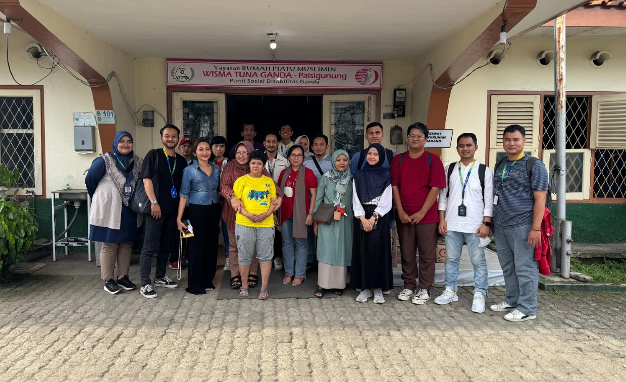 Group of about 15 people posing outside a building