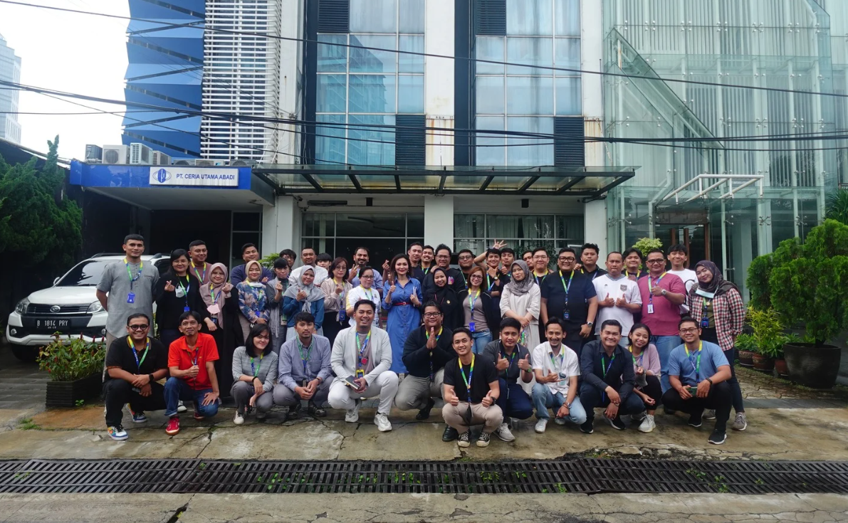 Group meeting photo in front of a modern glass building