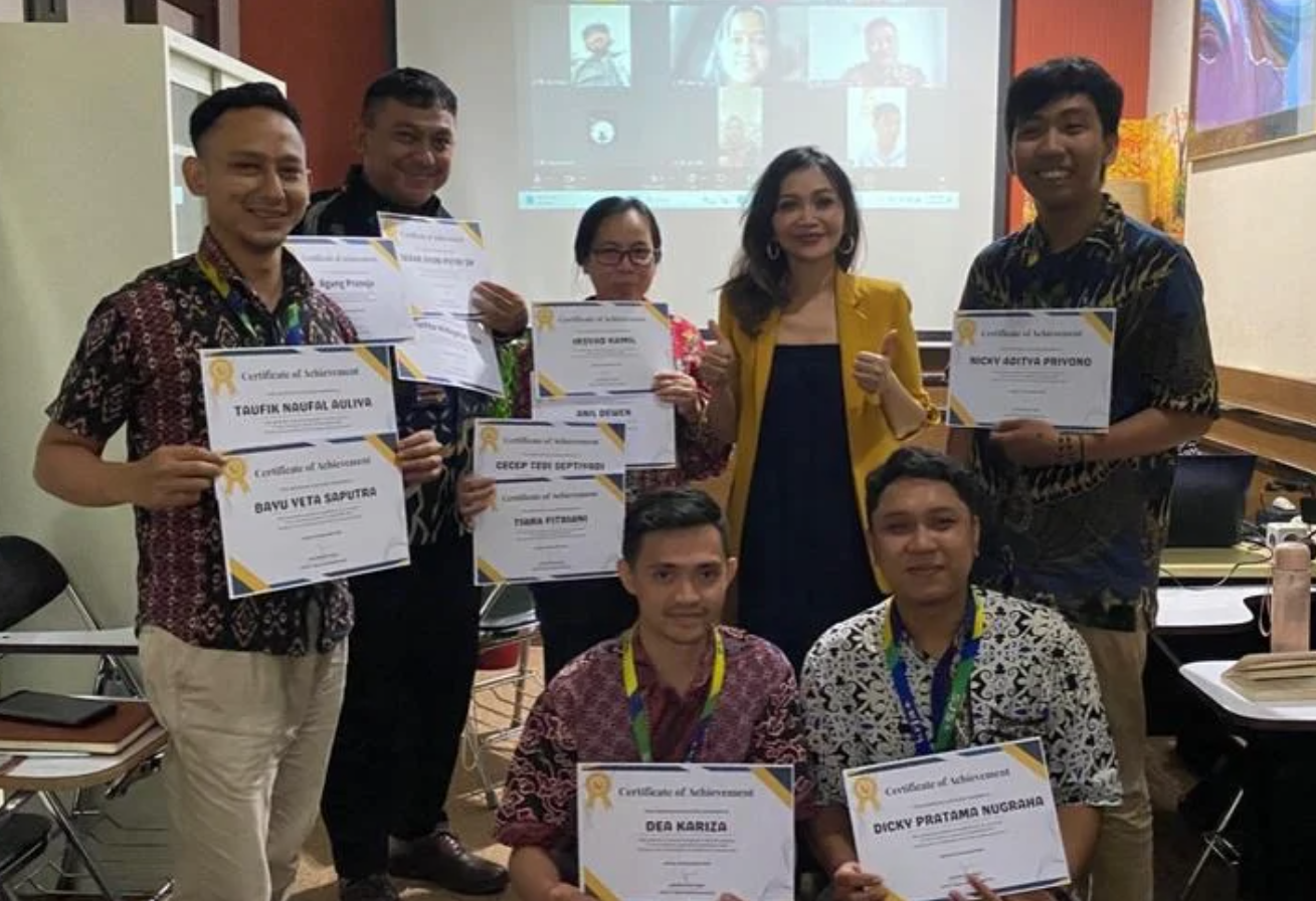 Group of employees holding certificates in an indoor room